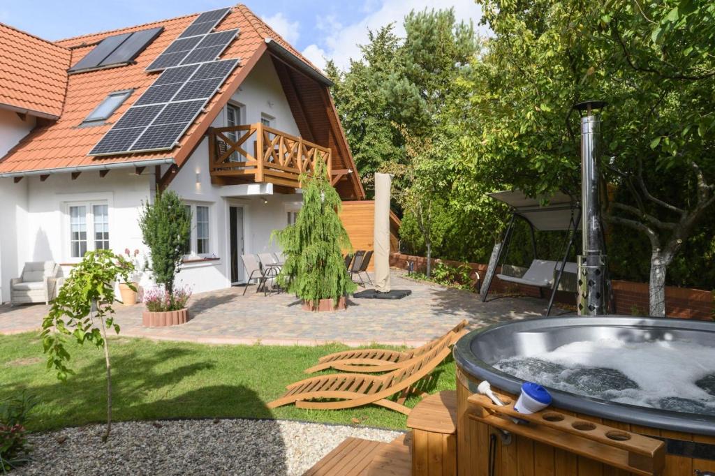 une arrière-cour avec un bain à remous et une maison dotée de panneaux solaires dans l'établissement Pensjonat Srebrny Klon, à Bytów