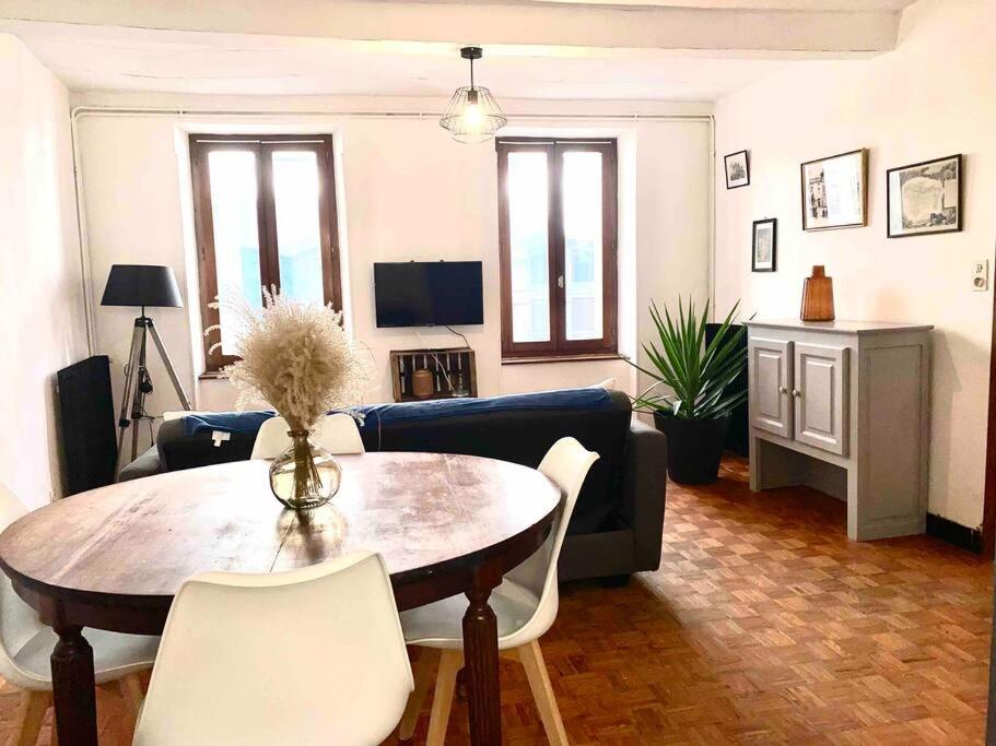 un salon avec une table et un canapé bleu dans l'établissement 3-CosyT2 à l'ancienne proche place Carnot BOX A BAGAGES GRATUITS, à Carcassonne