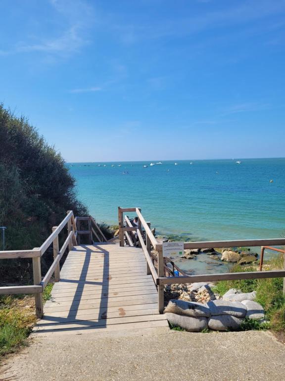 een houten promenade die naar de oceaan leidt op een strand bij 116 Brambles chine in Freshwater