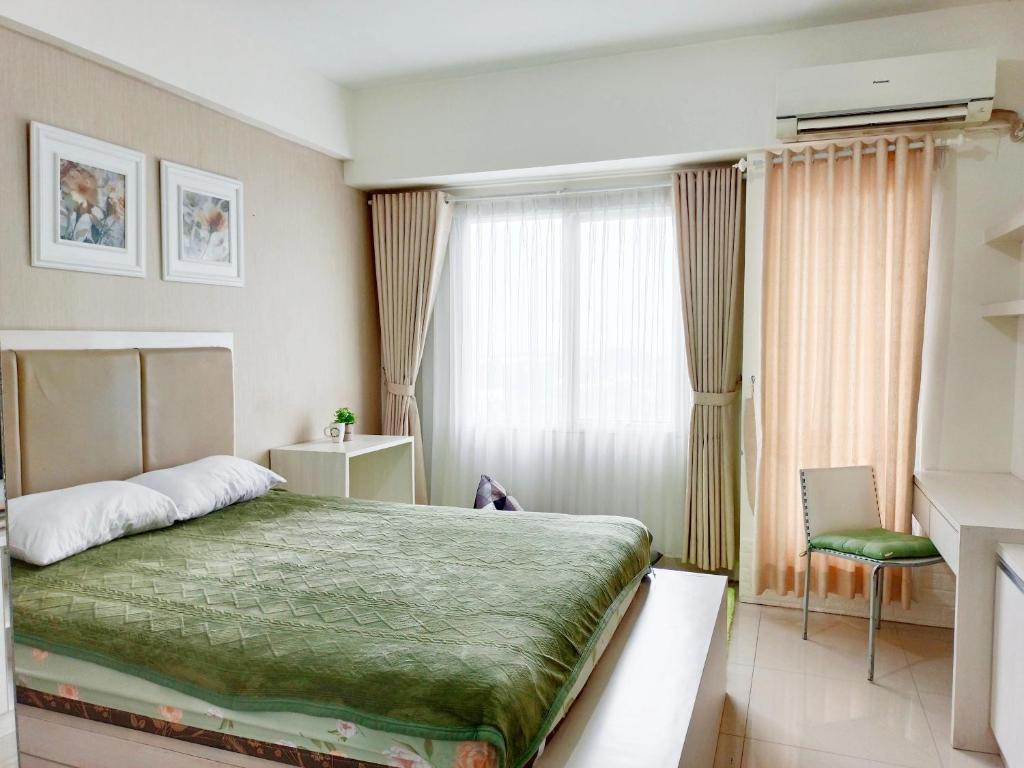 ein Hotelzimmer mit einem Bett und einem Fenster in der Unterkunft Studio Lavender Galeri Ciumbuleuit 2 in Bandung