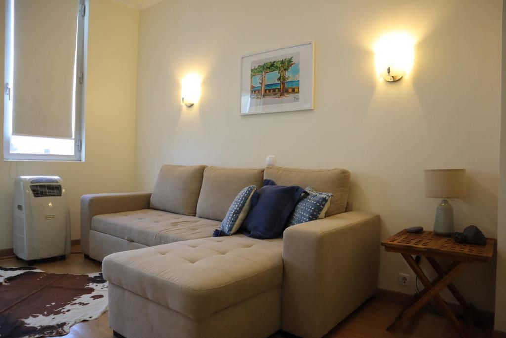 uma sala de estar com um sofá e uma mesa em Navio Azul Apartment no Funchal