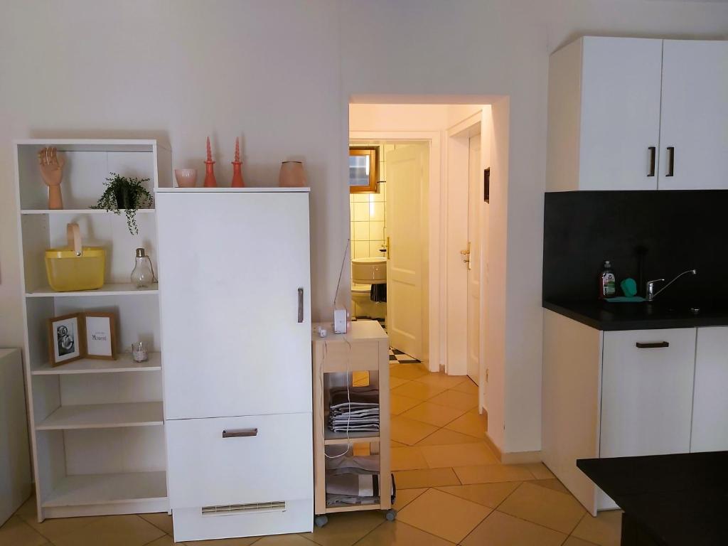 une cuisine avec des placards blancs et une chambre avec un couloir dans l'établissement Waldwinkel, à Treuchtlingen
