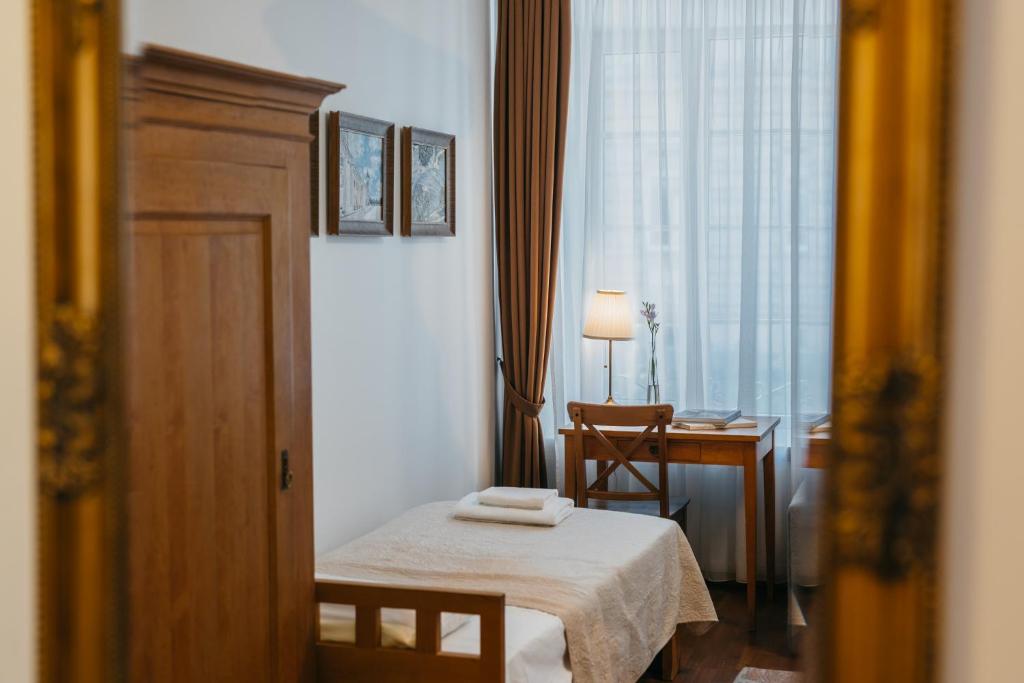 Habitación con cama, escritorio y ventana. en CATHEDRAL HOTEL Self-check in en Vilna