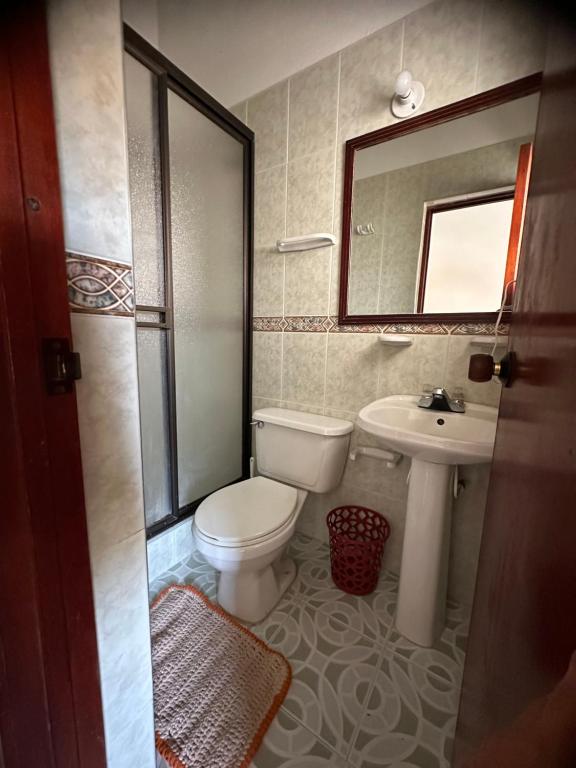 uma casa de banho com um WC, um lavatório e um espelho. em H-OSTELLO LA MERIDIANA em Villa de Leyva
