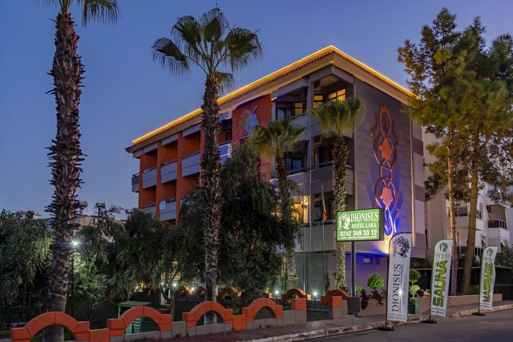 ein Gebäude mit Palmen davor in der Unterkunft Lara Olympos Hotel in Antalya