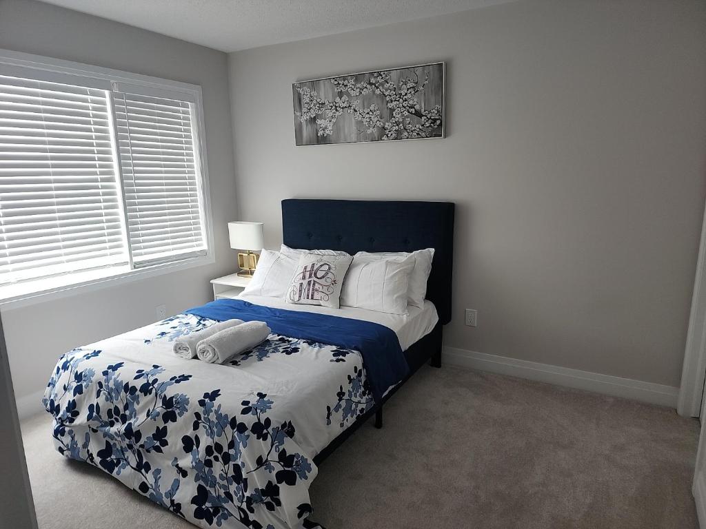 um quarto com uma cama com um edredão azul e branco em Dorothy's Place em Ottawa