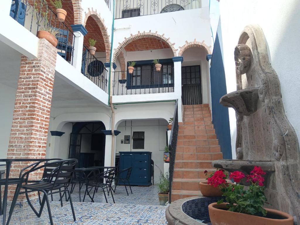 a courtyard of a building with tables and chairs at Hotel & Hostal Santuario in San Miguel de Allende