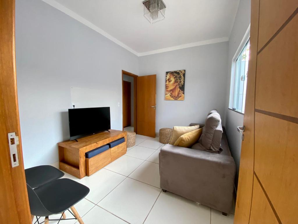 sala de estar con sofá y TV de pantalla plana en Casa no Centro da Cidade/Com ar condicionado, en Marília
