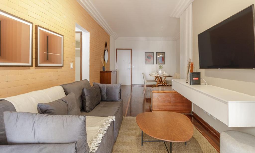 a living room with a couch and a flat screen tv at Tabas Apê estiloso no Jardim Botânico JB0002 in Rio de Janeiro