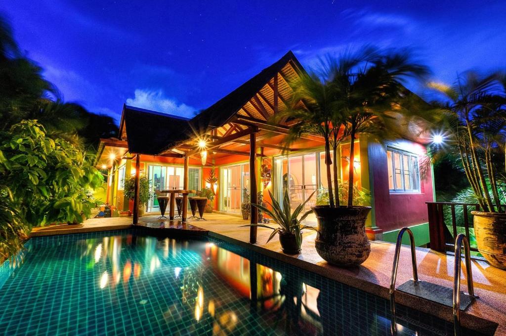 a villa with a swimming pool at night at Chaba Pool Villa in Nai Harn Beach