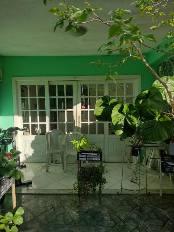 um quarto com uma parede verde e um pátio com cadeiras em Kitnet temporada Cabo Frio em Cabo Frio