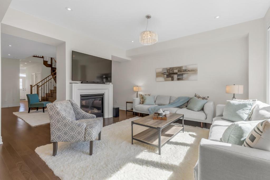 a living room with white furniture and a fireplace at Luxury 6 Bedroom - 4 Bathroom Detached Retreat Brampton / Mississauga Border in Brampton