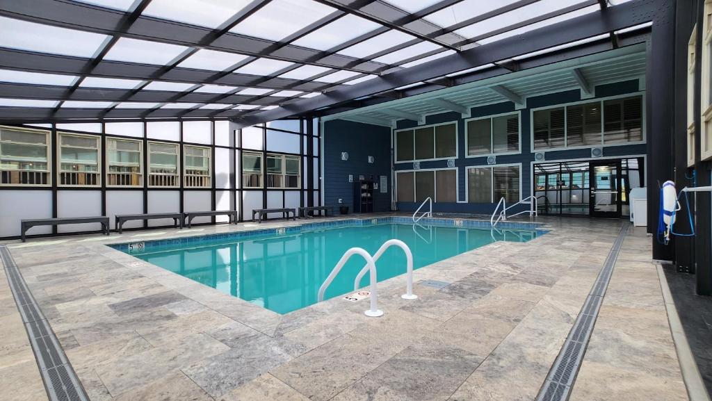 a swimming pool in a large building with a glass ceiling at Ramada Plaza by Wyndham Nags Head Oceanfront in Kill Devil Hills