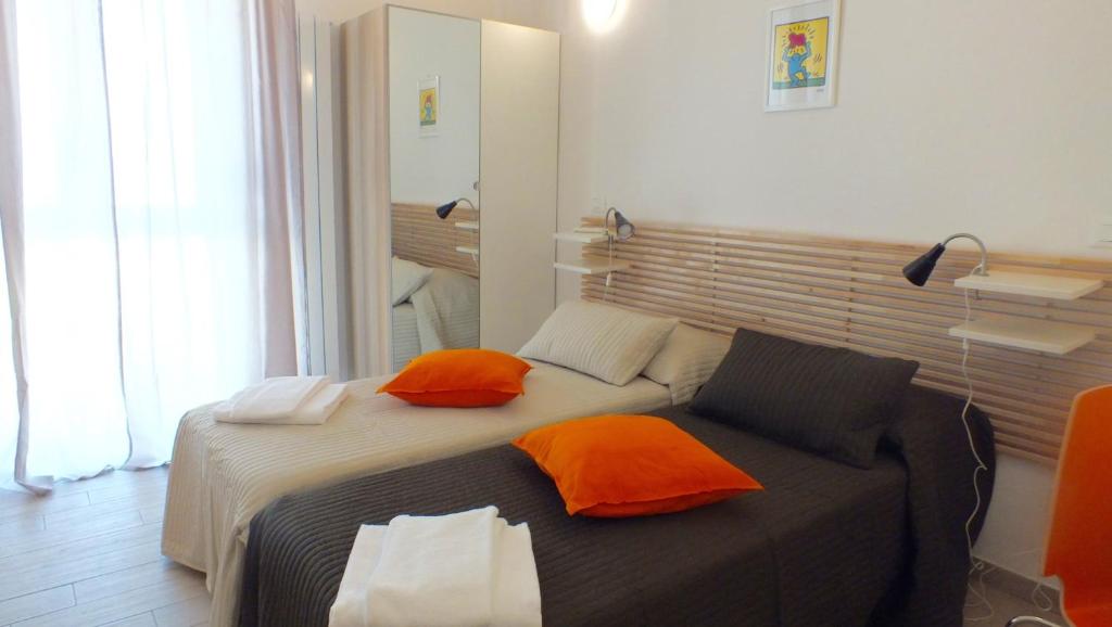 a bedroom with a bed with orange pillows on it at My Bnb Pisa in Pisa