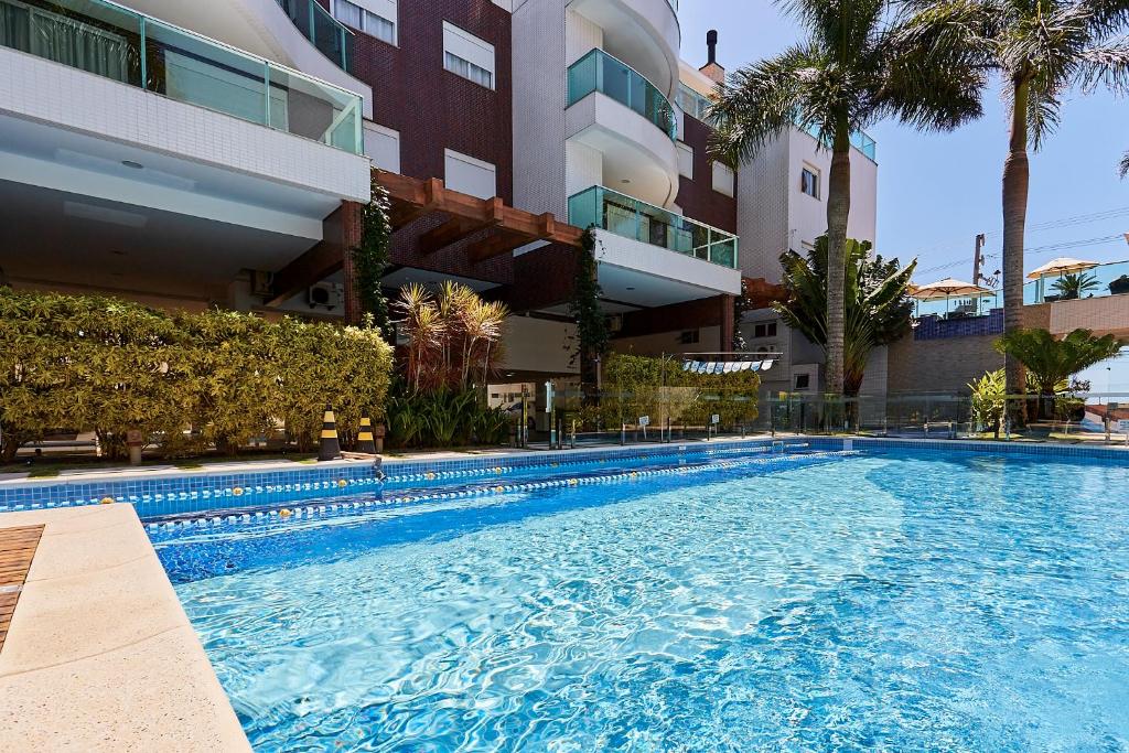 una piscina frente a un edificio en 1021 Apartamento em condomínio com piscina localizado na Avenida da praia do centro de Bombinhas, en Bombinhas