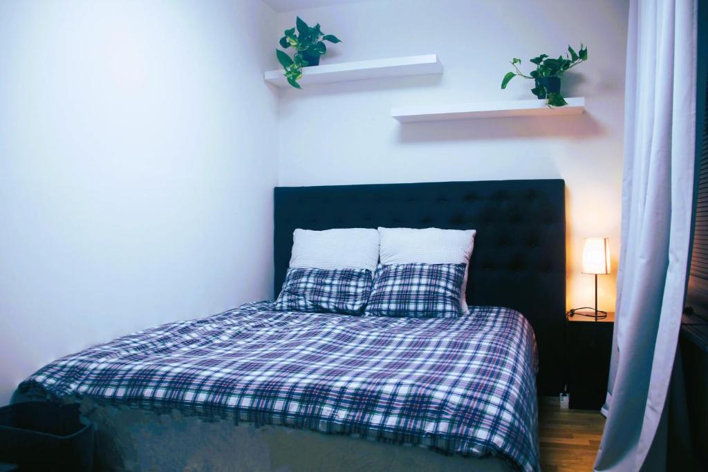 a bed with a plaid blanket and two pillows at Fully furnished room for rent in Märsta in Märsta