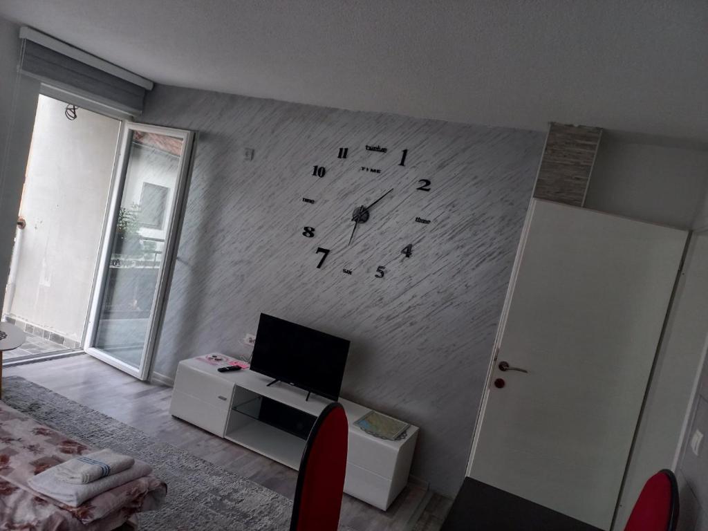 uma sala de estar com um relógio na parede em Adagio Studio Apartment em Plav