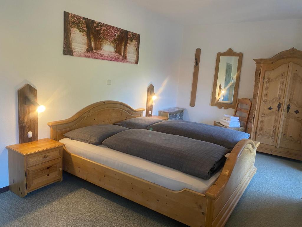 1 dormitorio con cama de madera y tocador de madera en Zimmer 2 am Manötscherhof, en Tires