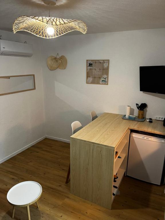 Cette chambre comprend un bureau, une table et une télévision. dans l'établissement Studio Chaleureux au Cap d’Agde, au Cap d'Agde