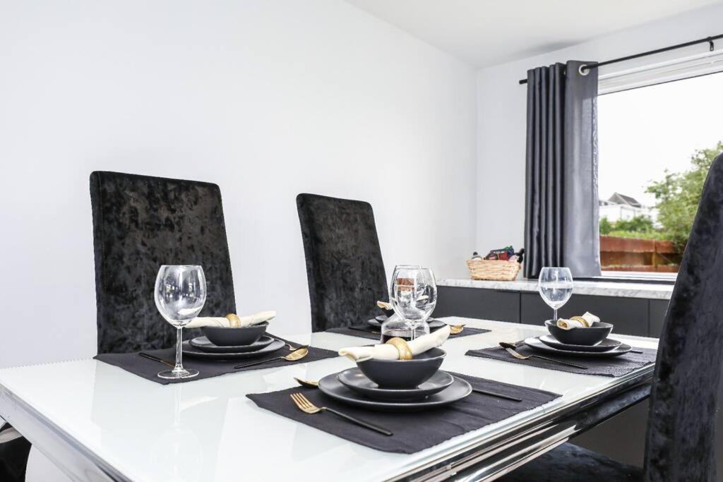 Doralan في Bishopbriggs: غرفة طعام مع طاولة مع كراسي وكاسات