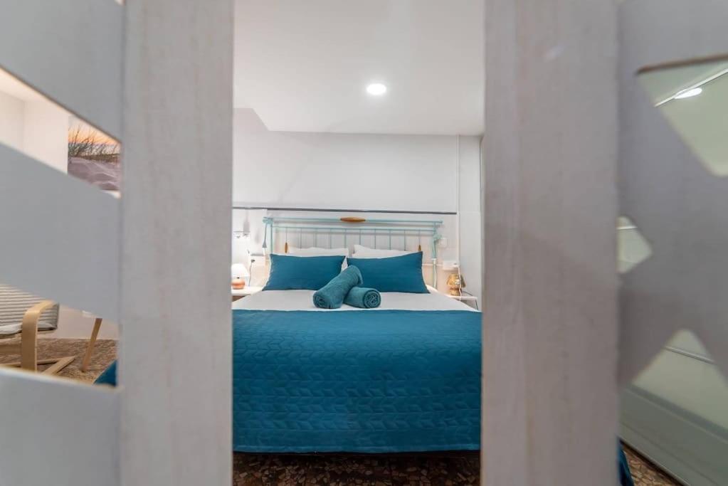 1 dormitorio con 1 cama con almohadas azules en La casita de la tortuga, en Melenara