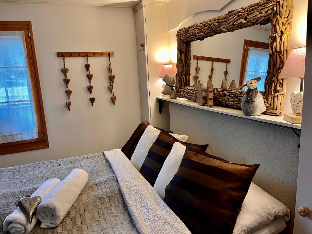 - une chambre avec un lit et un miroir mural dans l'établissement Chalet Apartment Serenity Lodge, à Charmey