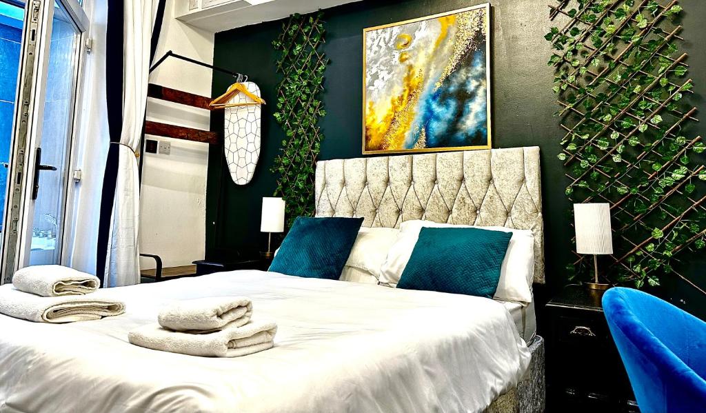 1 dormitorio con 1 cama con toallas en Duke and Duchess Apartments and Rooms - Private in Room Hot Tub Suites en Londres