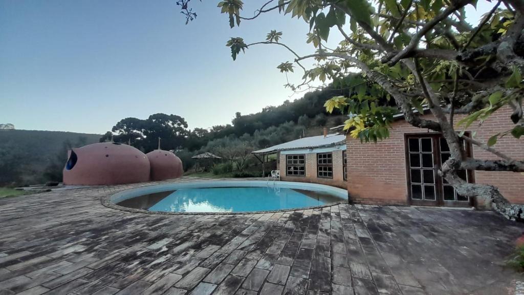 uma casa com piscina e um edifício em Espaço Lua Branca em Baependi