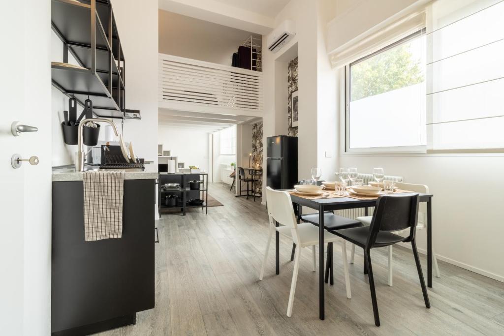 een keuken en eetkamer met een tafel en stoelen bij Navigli - Chic and Sophisticated Home in Milan in Milaan