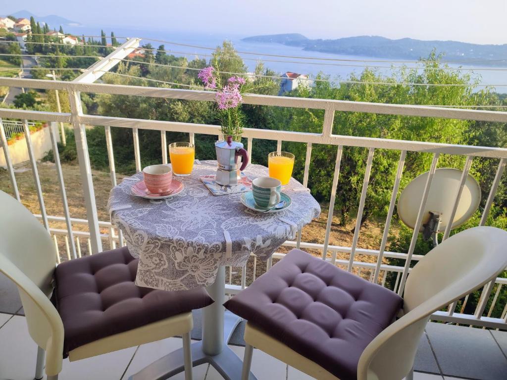 d'une table avec deux chaises et d'une table avec des boissons sur le balcon. dans l'établissement Orašac/Dubrovnik, à Orašac