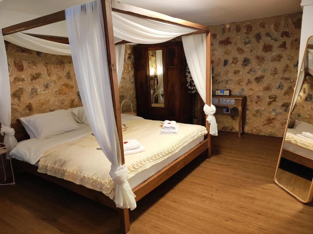 - une chambre avec un lit à baldaquin et un miroir dans l'établissement Αλώνι, à Nimfasía