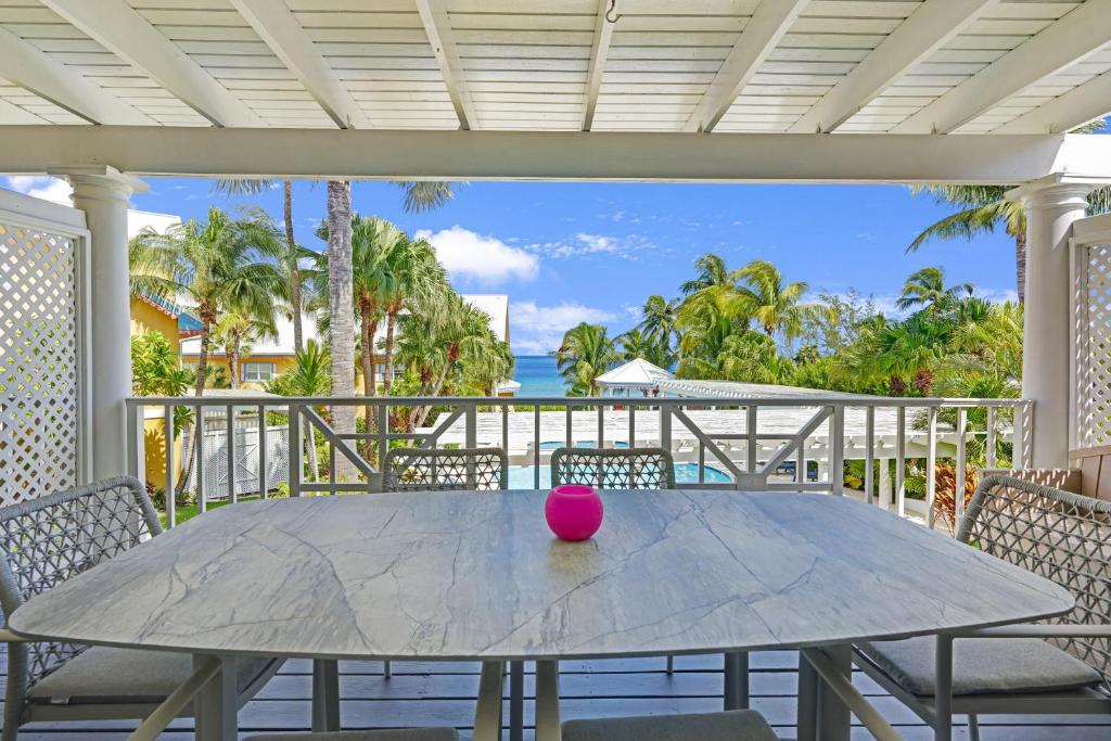 una bola rosa se sienta en una mesa en un porche en Coconut Bay Villas #116 en George Town