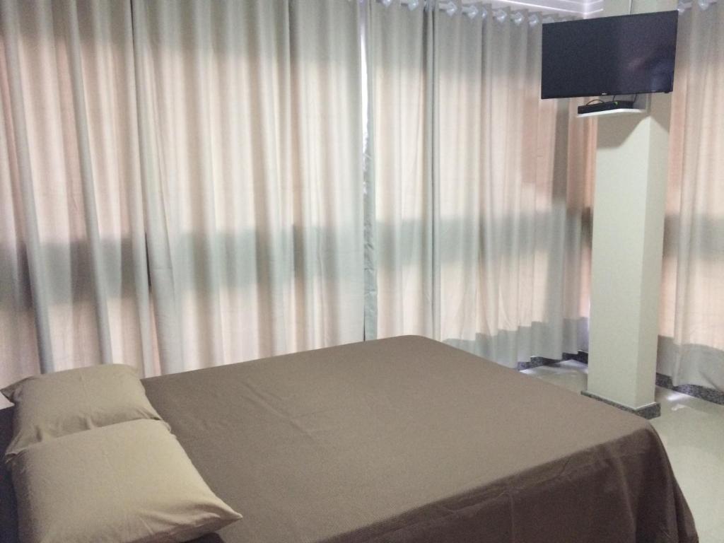 a hospital room with a bed and a television at Hotel Mascarello in Planalto