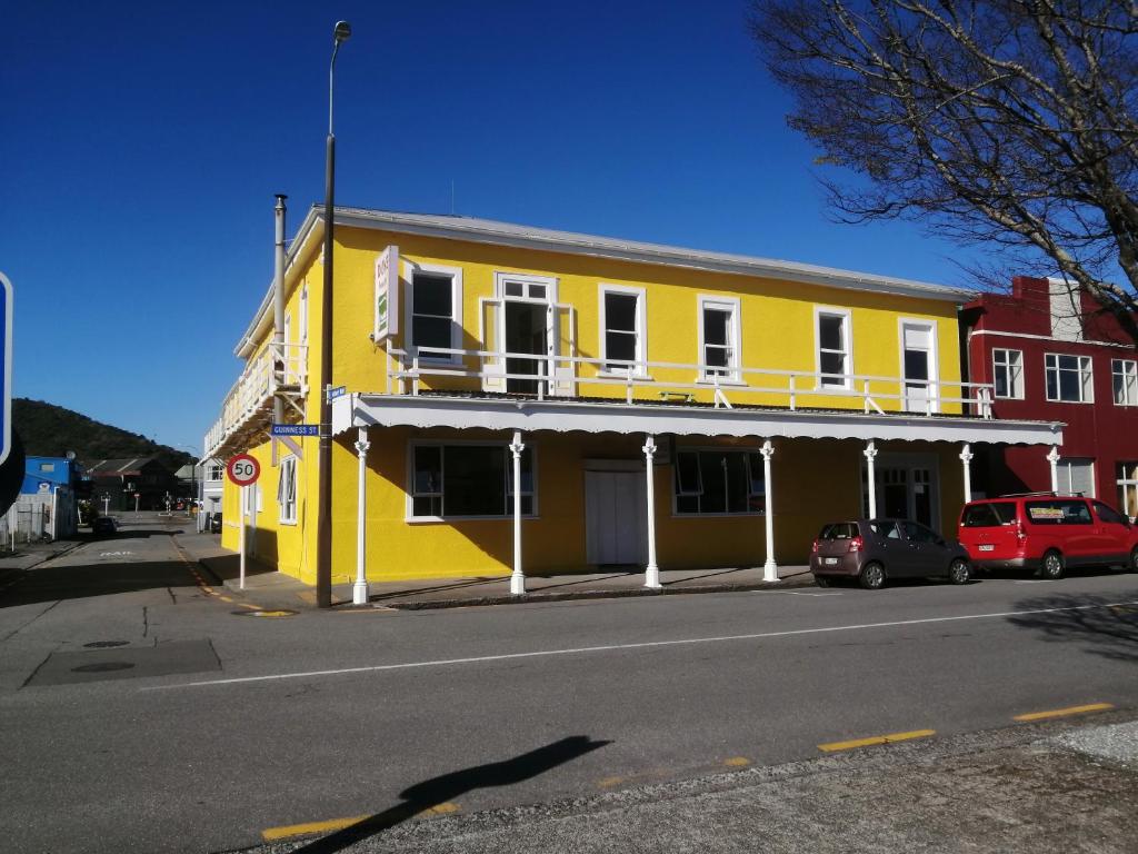 a yellow building on the side of a street at The Duke Hostel in Greymouth