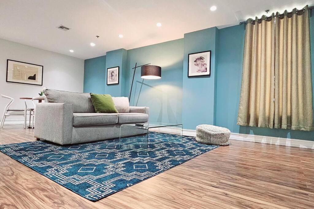 a living room with a couch and a blue wall at The Lofts on Clematis 404 Downtown West Palm Beach in West Palm Beach