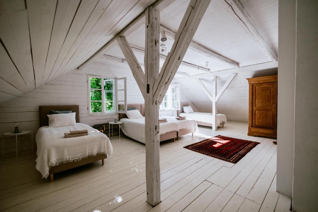 a attic bedroom with two beds and a table at Dwór Cieszkowskich 