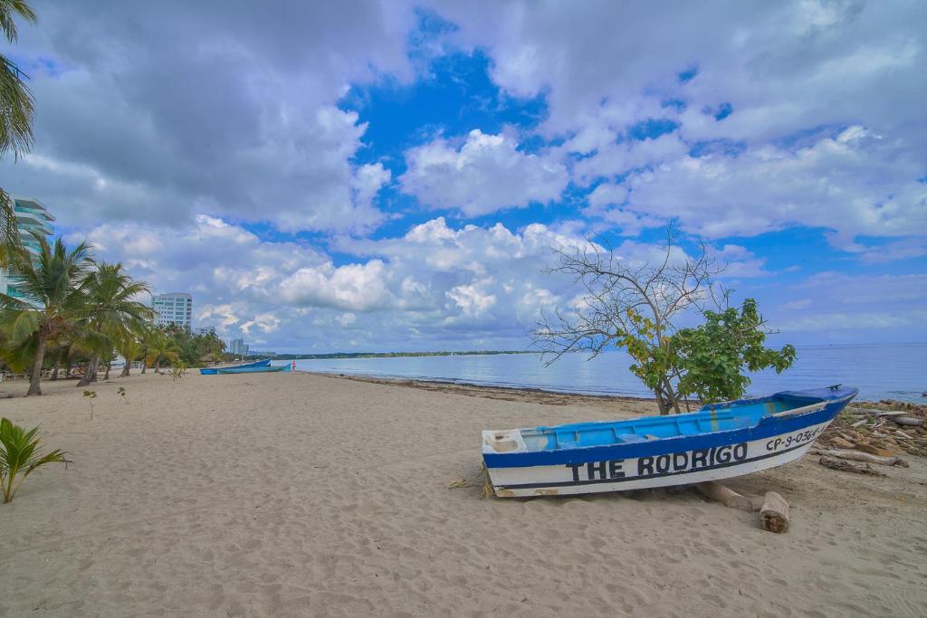 ein blaues Boot auf dem Sand am Strand in der Unterkunft Magico Apartamento Frente al Mar 3 Habitaciones C11A in Coveñas