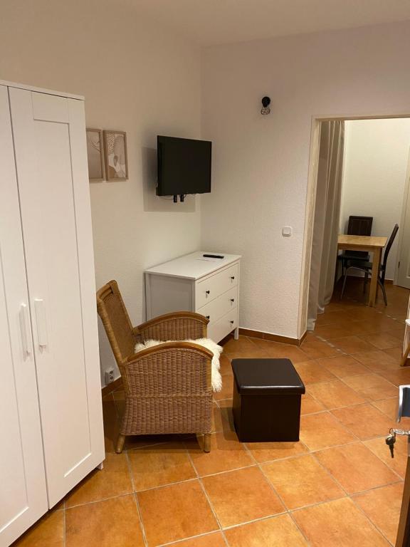 uma sala de estar com uma cadeira e uma televisão em Apartment mit Terrasse iP-TV Stellplatz em Krefeld