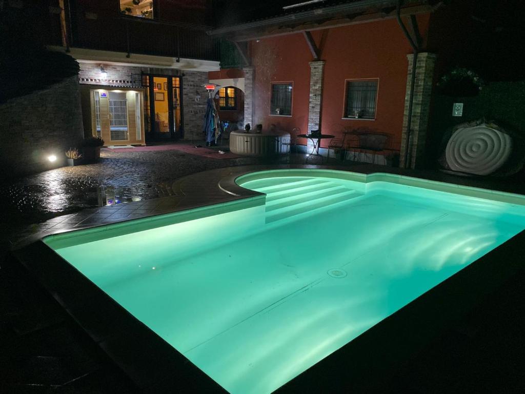 una piscina iluminada por la noche en GIRASOLE Wellness e Relax, en Fossano