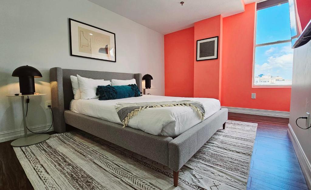 een slaapkamer met een bed en een rode muur bij The Lofts on Clematis 508 Downtown West Palm Beach in West Palm Beach