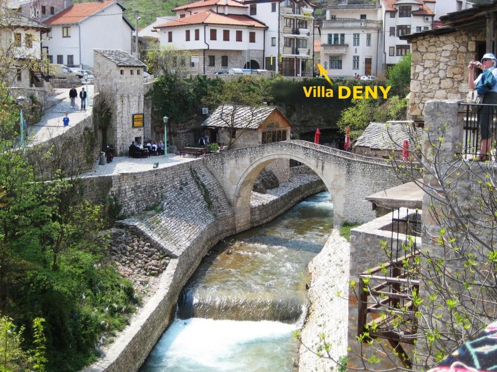 a stone bridge over a river in a city at Villa Deny Mostar in Mostar