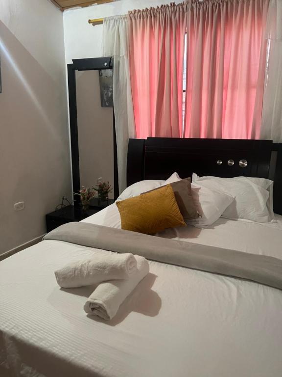 a bed with two white towels sitting on it at Casa Carolina in Santa Marta