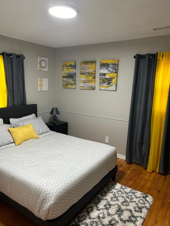 a bedroom with a bed and curtains and a rug at Serene Retreat! 3 minutes to downtown Richmond in Richmond