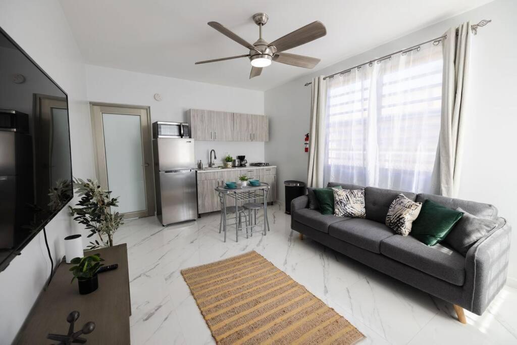 uma sala de estar com um sofá e uma cozinha em Lux Ramey Cir D 2 king bed w/Wi-Fi near airport. em Aguadilla