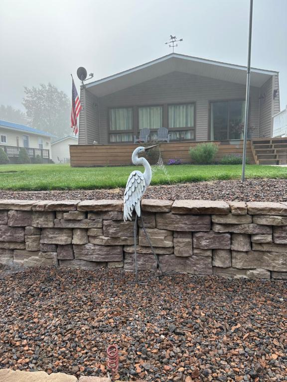 a bird standing on a stone wall in front of a house at Channel Escape in Coldwater
