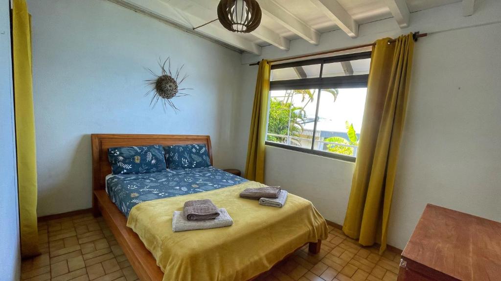 Villa Te Miti في بوناويا: غرفة نوم مع سرير مع عنكبوت على الحائط