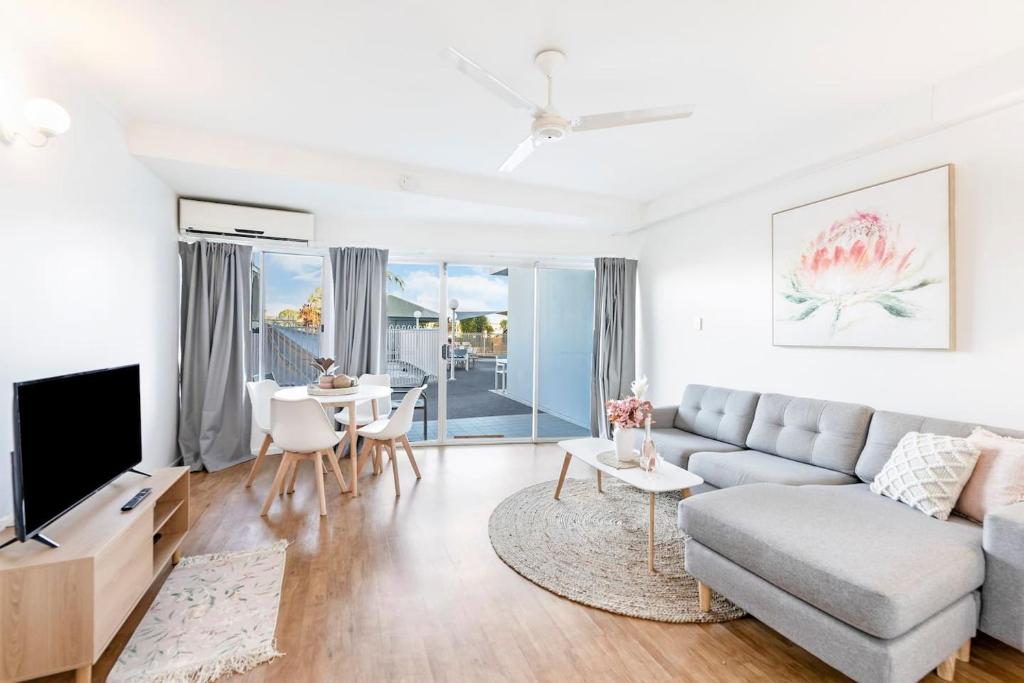 a living room with a couch and a tv at Cullen Bay Calm - Tropical Poolside Living in Larrakeyah