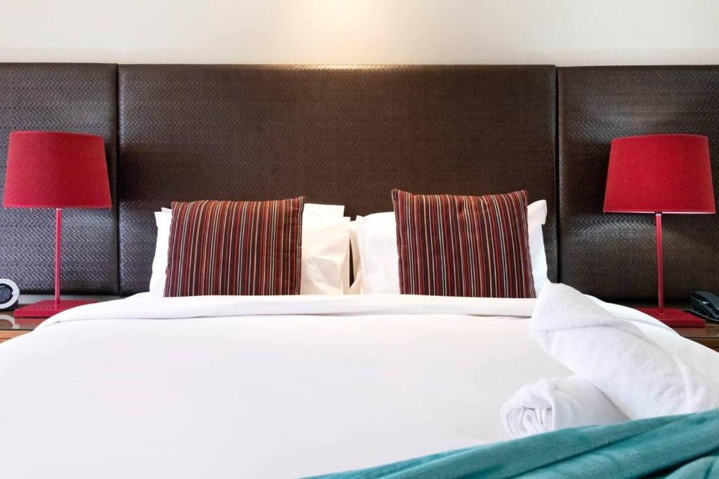 A bed or beds in a room at Waterfront on the Esplanade with Tropical Pool
