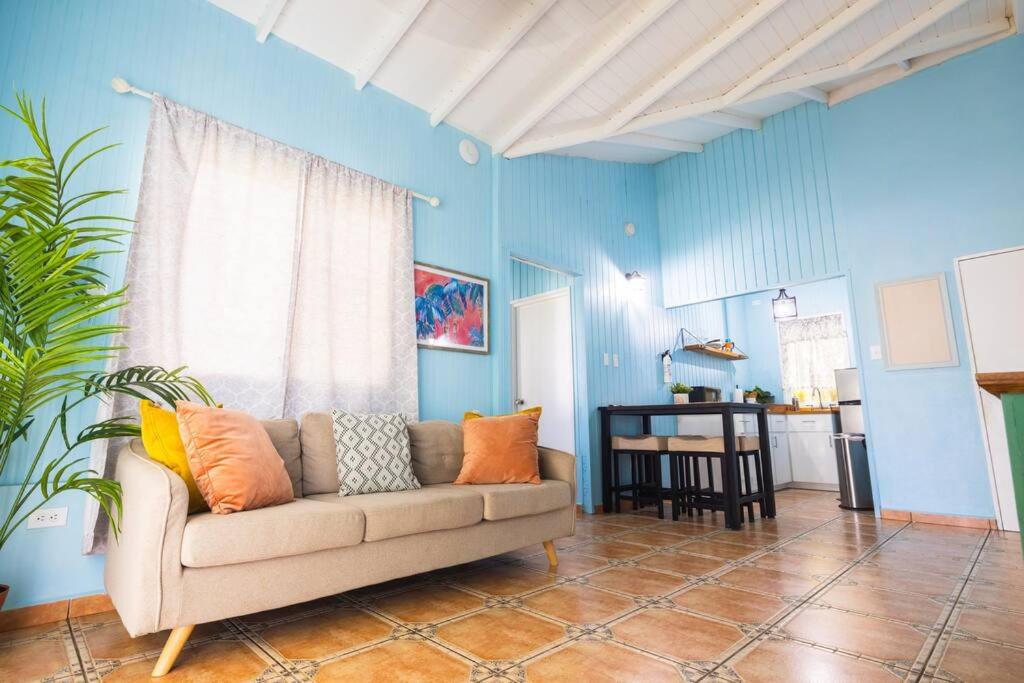 uma sala de estar com um sofá e uma parede azul em Jobos Beach Apt #2 near food truck and beach em Isabela