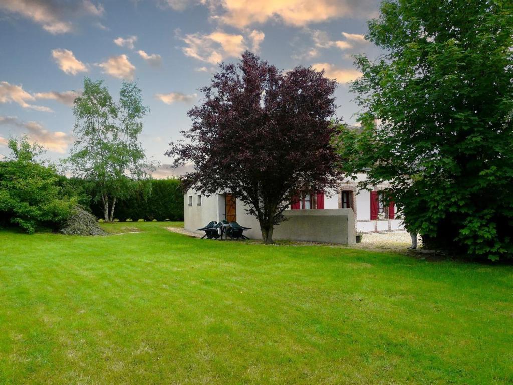 une maison blanche avec un arbre dans la cour dans l'établissement Gîte La Saucelle, 3 pièces, 4 personnes - FR-1-581-13, 